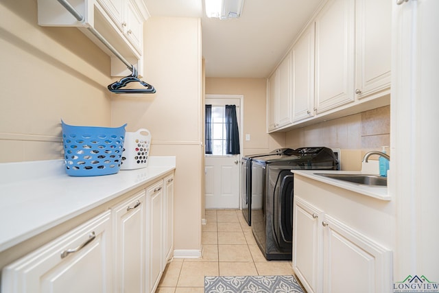 laundry room featuring sink, cabinets, washing machine and dryer, and light tile patterned flooring