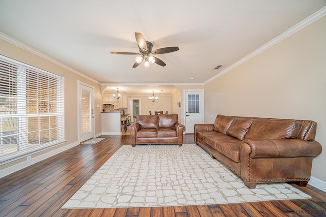 living room with ceiling fan with notable chandelier, wood-type flooring, and ornamental molding