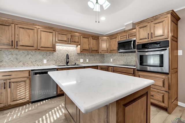 kitchen with crown molding, sink, appliances with stainless steel finishes, tasteful backsplash, and a kitchen island