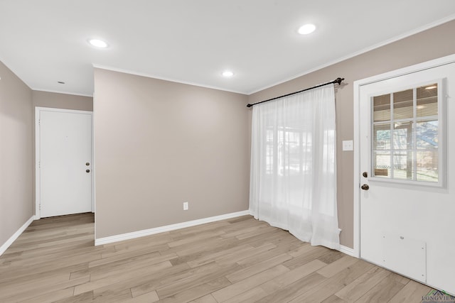 foyer with light hardwood / wood-style floors and crown molding