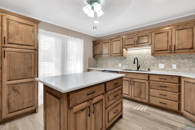 kitchen featuring ceiling fan, sink, backsplash, crown molding, and a kitchen island