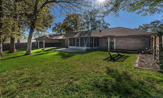 rear view of house featuring a yard and a patio