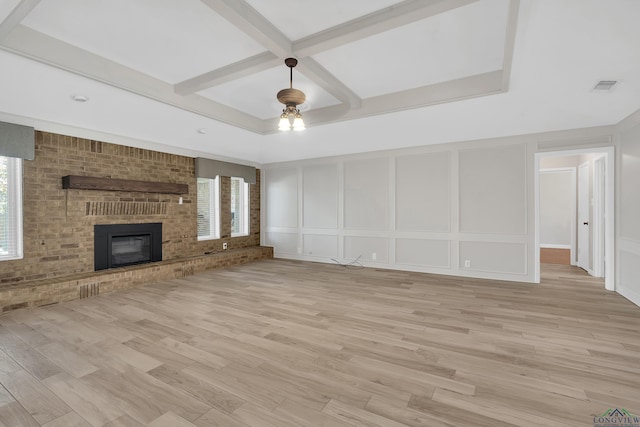 unfurnished living room with light hardwood / wood-style flooring, coffered ceiling, and a brick fireplace