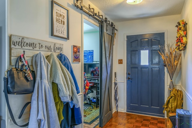 foyer entrance featuring a barn door and a textured ceiling