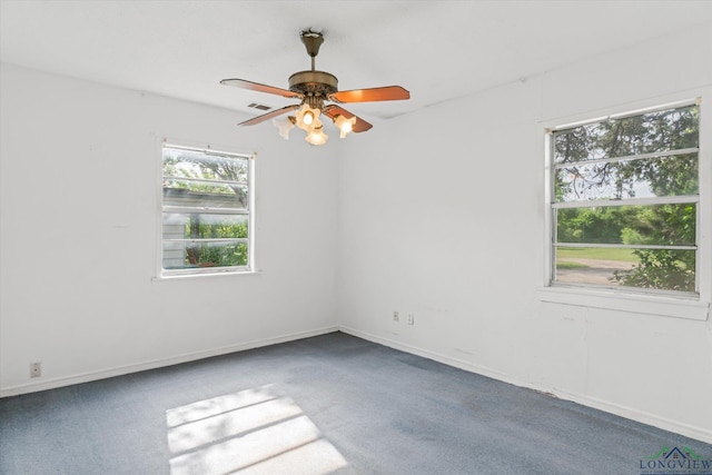 carpeted spare room featuring visible vents, baseboards, and ceiling fan