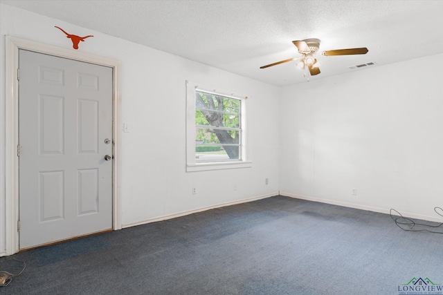 unfurnished room featuring a ceiling fan, a textured ceiling, visible vents, baseboards, and dark colored carpet