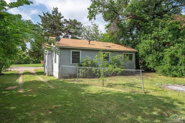 back of house with a lawn and fence