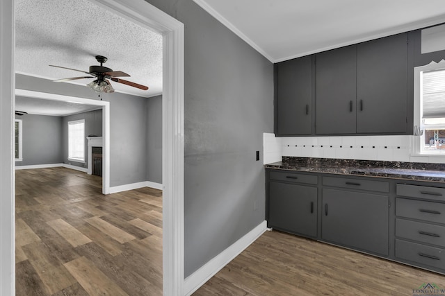 300 Hailey Dr, Longview, TX 75602 - kitchen featuring dark countertops, ceiling fan, dark wood-type flooring, baseboards, and ornamental molding