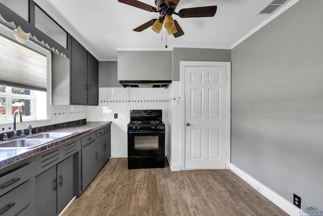 300 Hailey Dr, Longview, TX 75602 - kitchen featuring black gas range, a sink, dark countertops, ventilation hood, and ceiling fan