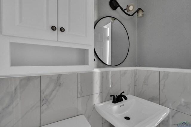 300 Hailey Dr, Longview, TX 75602 - half bathroom with a sink, tile walls, and toilet