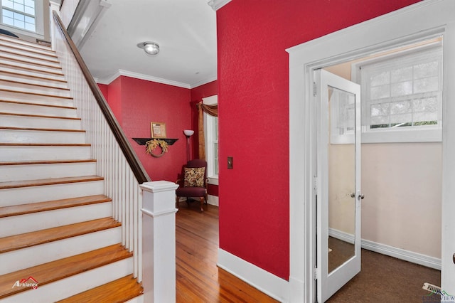 staircase with hardwood / wood-style flooring and ornamental molding