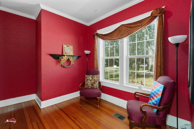 sitting room featuring wood-type flooring and crown molding