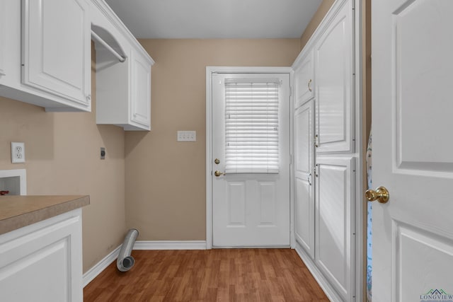 laundry room with hookup for an electric dryer, washer hookup, light hardwood / wood-style floors, and cabinets