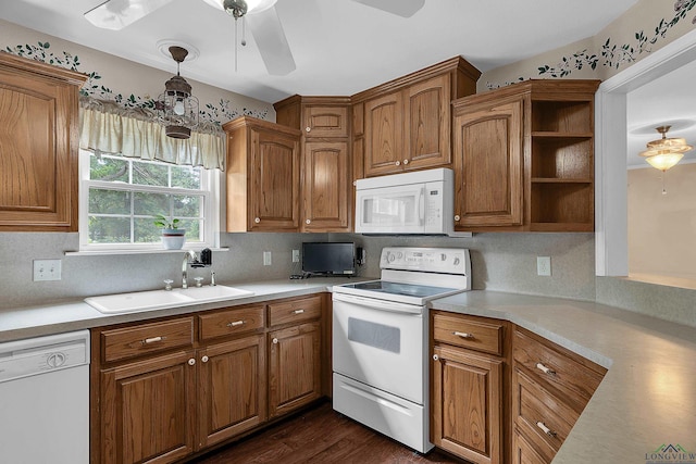 kitchen featuring backsplash, white appliances, sink, and hanging light fixtures