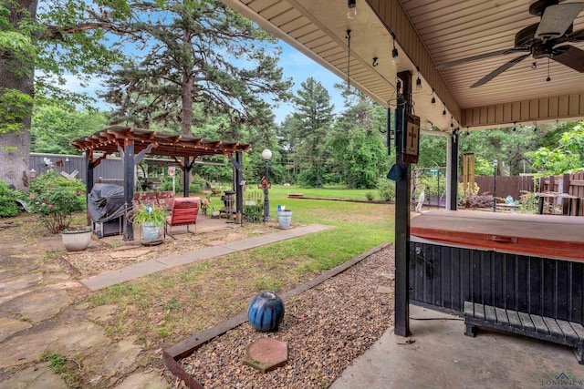 view of patio / terrace with ceiling fan, a pergola, and a hot tub