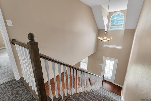 stairway featuring a notable chandelier