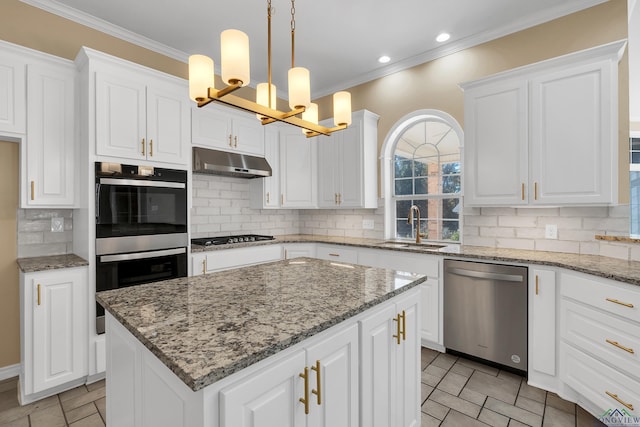 kitchen with decorative light fixtures, decorative backsplash, a center island, and stainless steel appliances