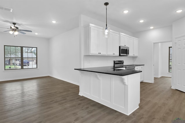 kitchen featuring ceiling fan, appliances with stainless steel finishes, white cabinetry, hanging light fixtures, and dark hardwood / wood-style floors