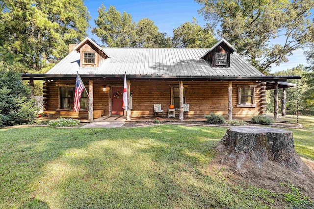 log cabin with covered porch and a front lawn