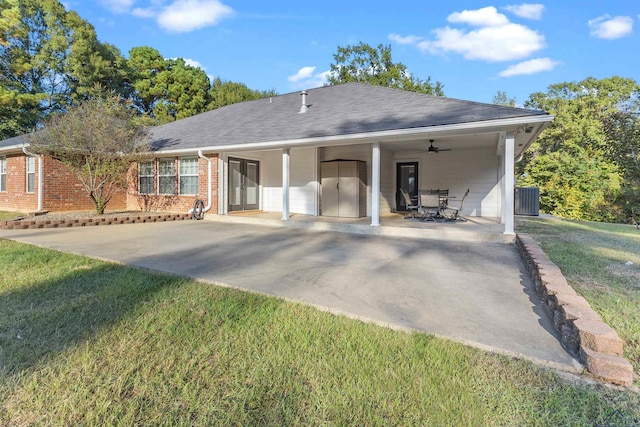 view of front of house featuring central air condition unit, ceiling fan, a front lawn, and a patio