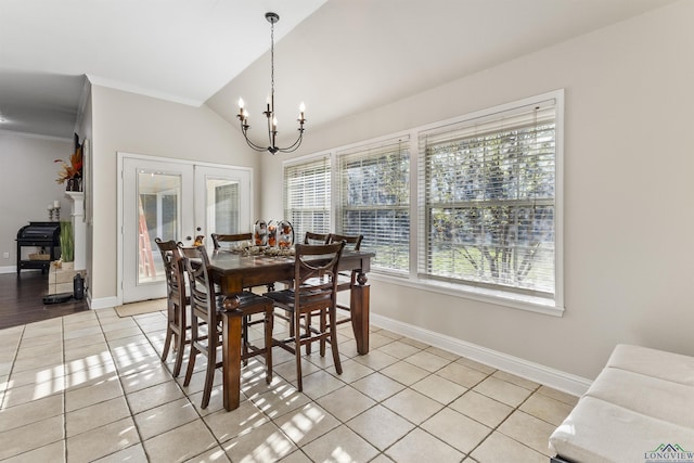 tiled dining area with a chandelier, french doors, ornamental molding, and lofted ceiling