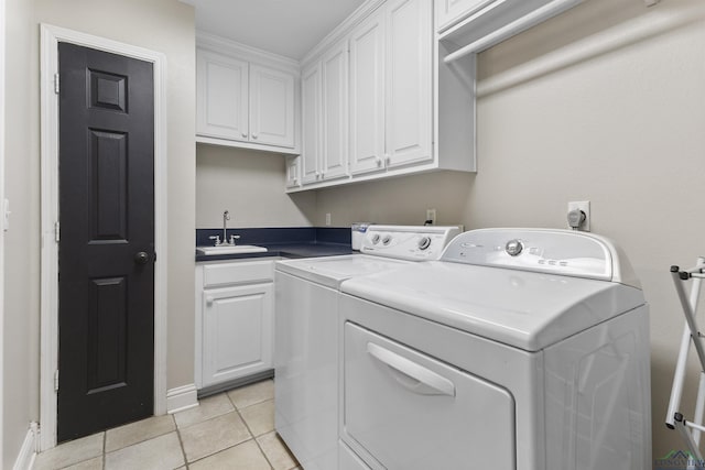 laundry room with cabinets, light tile patterned flooring, washer and clothes dryer, and sink