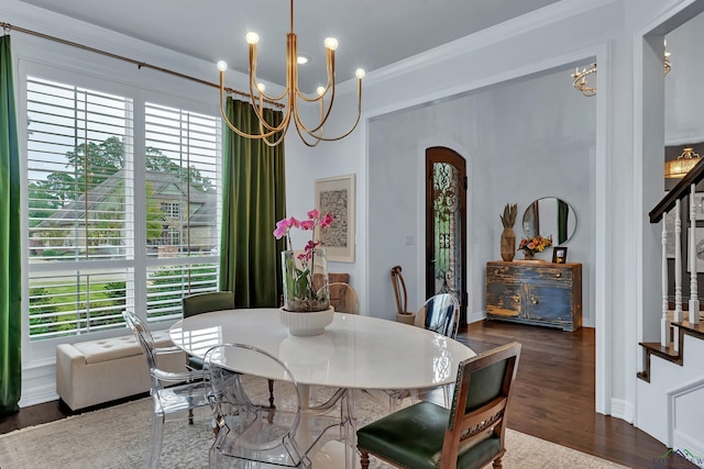 dining space with crown molding, dark wood-type flooring, and an inviting chandelier