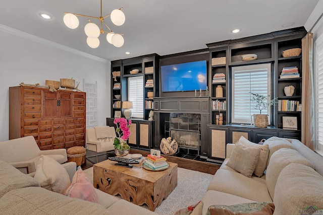 living room featuring a chandelier, crown molding, and a tiled fireplace