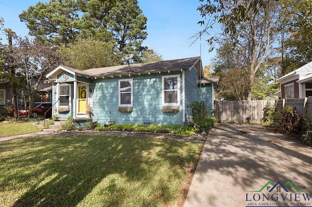 bungalow with fence and a front lawn