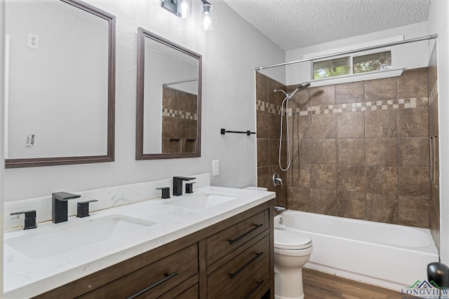 204 Half St, Lindale, TX 75771 - bathroom with a textured ceiling, toilet, double vanity, shower / bathtub combination, and wood finished floors