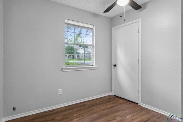 204 Half St, Lindale, TX 75771 - unfurnished bedroom with dark wood finished floors, baseboards, ceiling fan, and a textured ceiling
