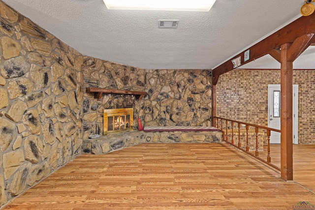 living room featuring a fireplace, a textured ceiling, and light wood-type flooring