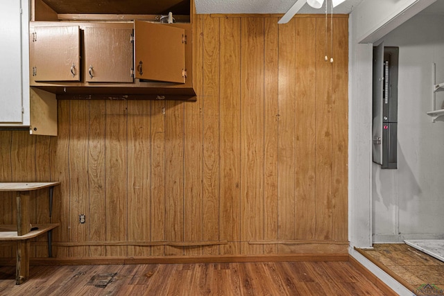 interior space with wooden walls, hardwood / wood-style floors, and ceiling fan