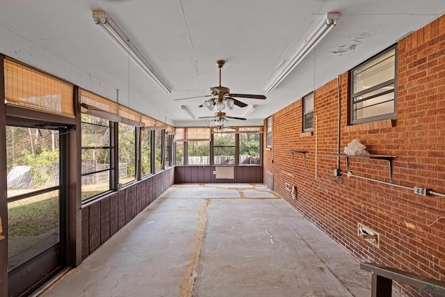 unfurnished sunroom with ceiling fan