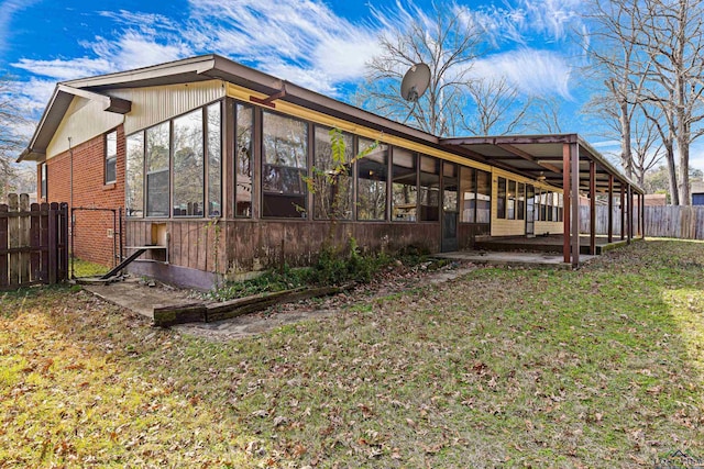 view of property exterior with a yard and a sunroom