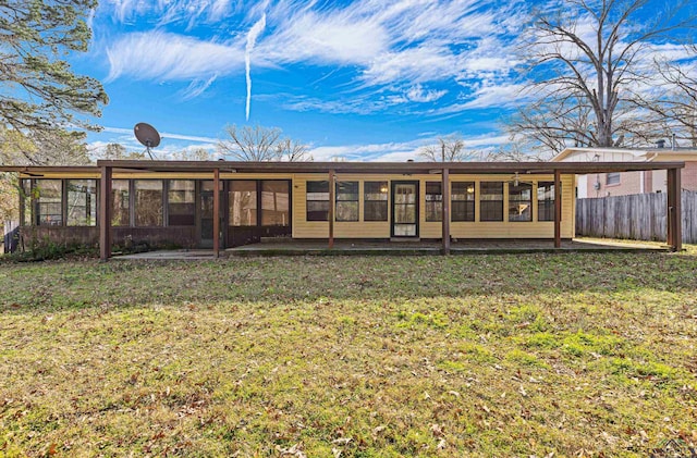 back of house featuring a yard and a sunroom