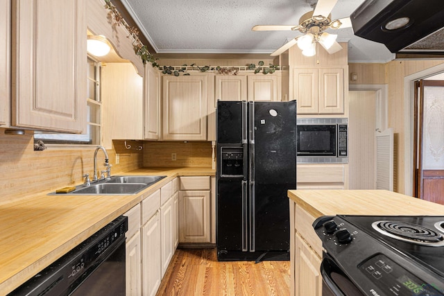 kitchen featuring light hardwood / wood-style flooring, black appliances, crown molding, wood counters, and sink