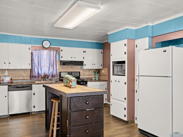 kitchen with black gas range, a center island, sink, stainless steel dishwasher, and white fridge