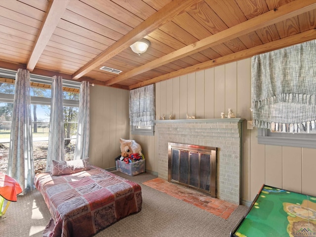 bedroom featuring beam ceiling, a brick fireplace, carpet floors, wooden walls, and wood ceiling