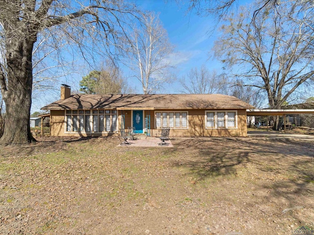 view of front facade with a front lawn and a carport