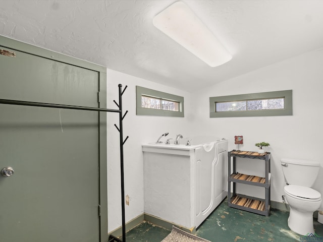 bathroom featuring a healthy amount of sunlight, vaulted ceiling, and toilet