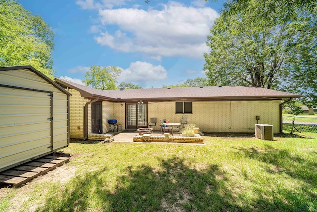 207 E Eleanor St, Gladewater, TX 75647 - rear view of house with a patio area, brick siding, a storage unit, and french doors