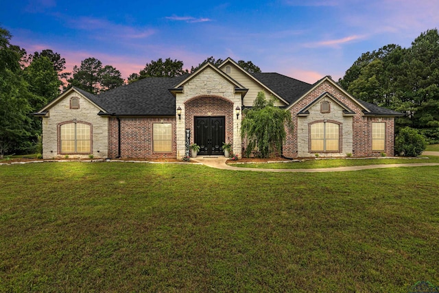 1844 Raven Rd, Diana, TX 75640 - french provincial home featuring a shingled roof, a lawn, stone siding, and brick siding