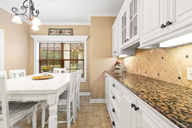 1844 Raven Rd, Diana, TX 75640 - kitchen with stone tile floors, backsplash, glass insert cabinets, white cabinetry, and baseboards