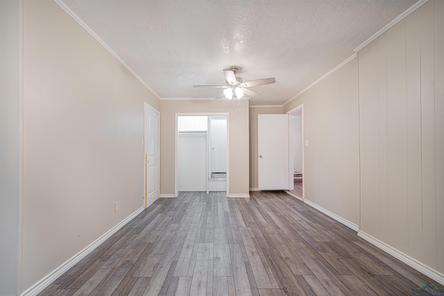 empty room featuring hardwood / wood-style floors, a textured ceiling, ceiling fan, and crown molding