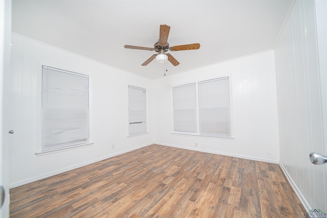 spare room with crown molding, ceiling fan, and dark wood-type flooring