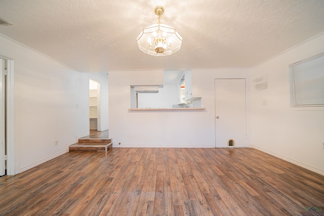 unfurnished living room featuring a textured ceiling, dark hardwood / wood-style flooring, and an inviting chandelier