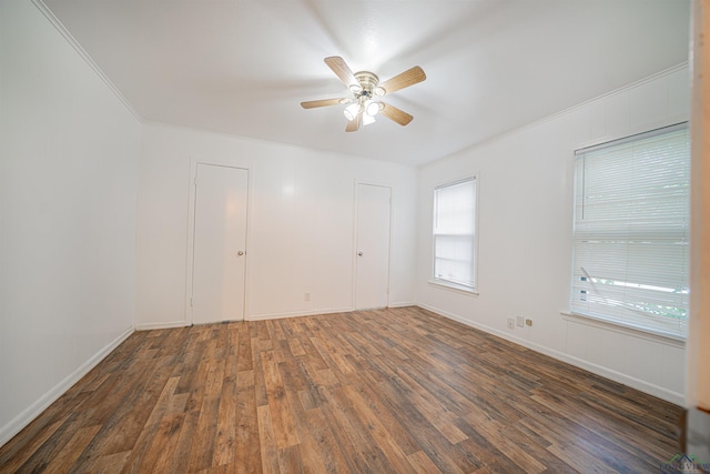 empty room featuring ceiling fan, dark hardwood / wood-style flooring, and crown molding