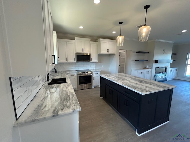 kitchen featuring white cabinetry, sink, a center island, hanging light fixtures, and appliances with stainless steel finishes