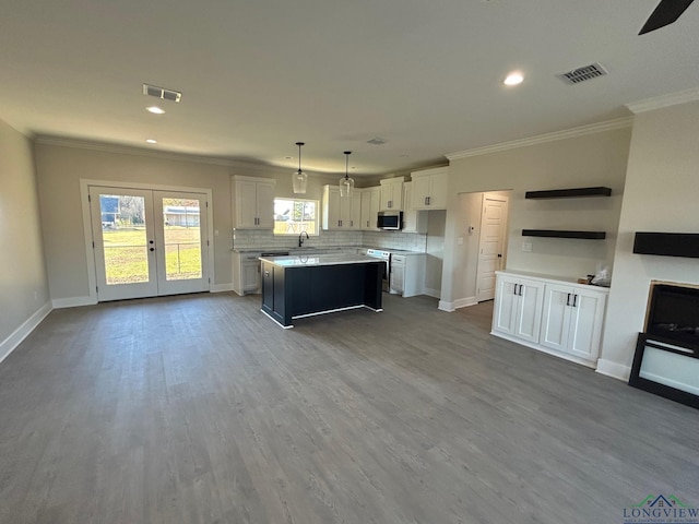 kitchen with pendant lighting, white cabinets, stainless steel appliances, and a kitchen island